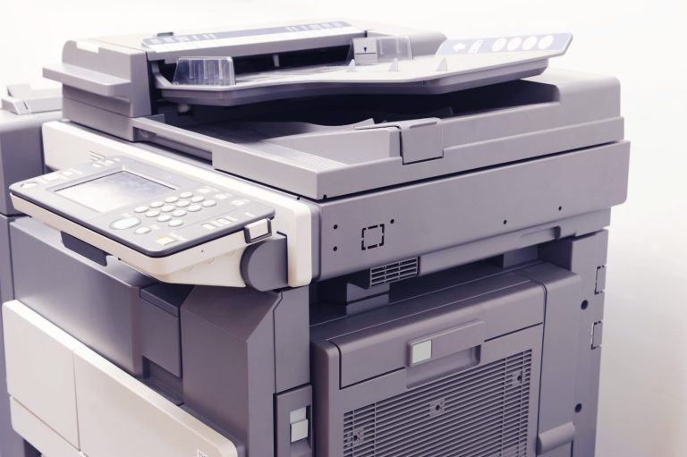 Technician fixing a printer, representing printer repair services and maintenance expertise.